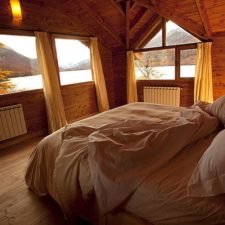 Room interior with double bed, made complete of native woods and overlooking the river.