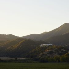 Panoramic view of the valley and the hotel building on a hill.