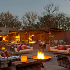 Outside terrace with living rooms around a fire. Rustic and relaxed environment.