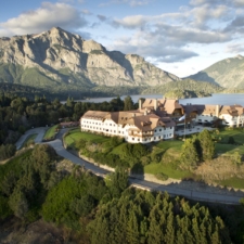 Beautiful panoramic view of the hotel on top of a gentle hill, surrounded by forest lakes.