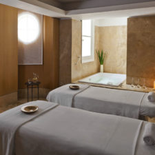 View of the spa room, with massage beds and jacuzzy with warm colored marble floors and walls.