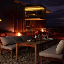 Cozy evening with open fire and hot coals. Dinner outdoors at sunset and view of a room with glass windows
