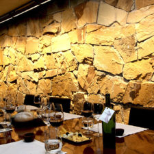 Beautiful restaurant with a stone wall. Wines and artisan breads