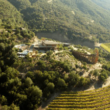 Panoramic view of the hotel on a hill with a wide view of the valley with vineyards.