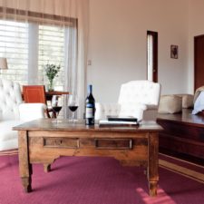 Room with a double bed and a living room on a slope with a warm atmosphere to enjoy a good wine.