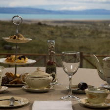 Tea table set with fine porcelain overlooking grasslands.