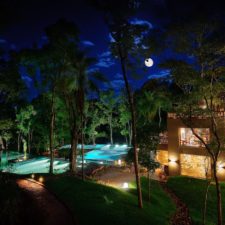 Panoramic night view of the hotel pool. Beautiful lighting of a full moon. hotel surrounded by tropical forest.