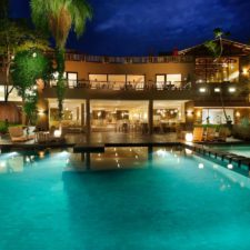 Panoramic night view of the hotel pool. Beautiful lighting of the terrace and interiors of the hotel.