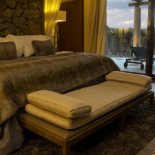 Beautiful room with stone wall and fine woods. Soft textures, large bed and large window overlooking a terrace and vineyard.
