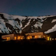 Panoramic night view of the hotel overlooking the snowy mountains.