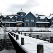 View from the snowy pier to Boutique Hotel located steps from the lake. Beautiful winter landscape.
